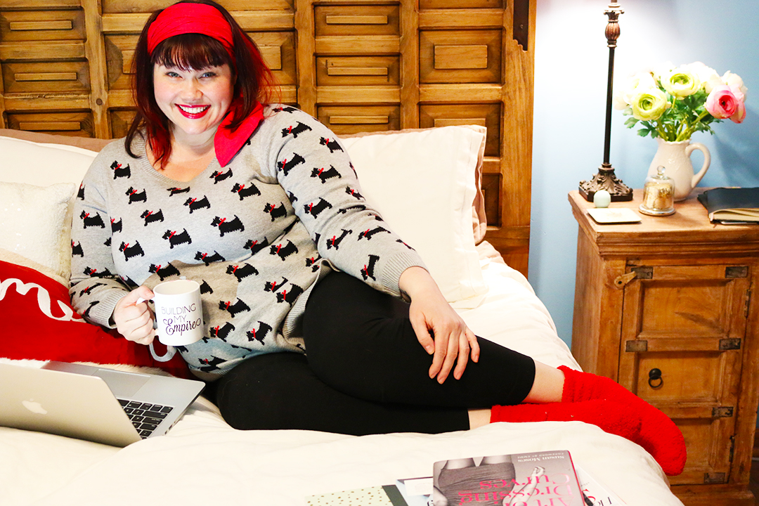 Plus Size Blogger Working from Home in Dog Sweater with red fluffy socks and red headscarf