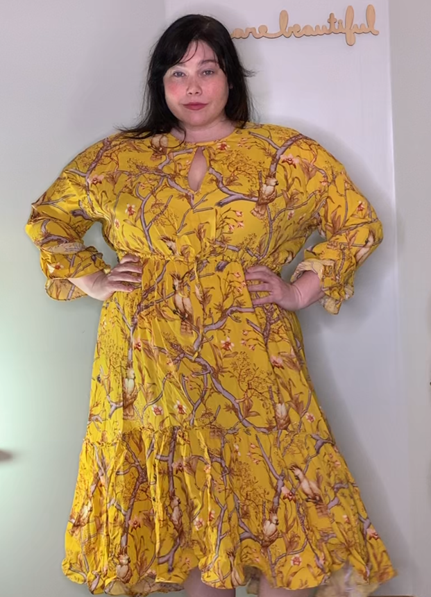 Chicago Blogger Amber wears a yellow bird print ruffled dress from H&M's plus size line.